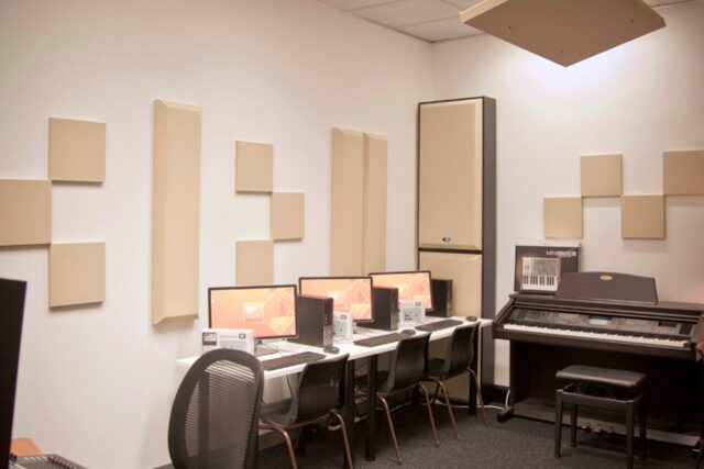 Beige acoustic panels and bass trap on recording studio wall