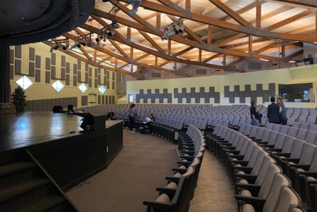 Empty auditorium with grey acoustic panels on wall