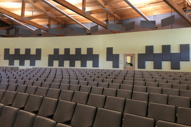 Empty auditorium with grey acoustic panels on wall and ceiling