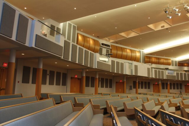 Empty church aisles with grey acoustic panels on walls