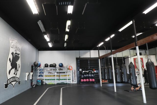 Boxing and fitness gym with black acoustic panels on ceiling
