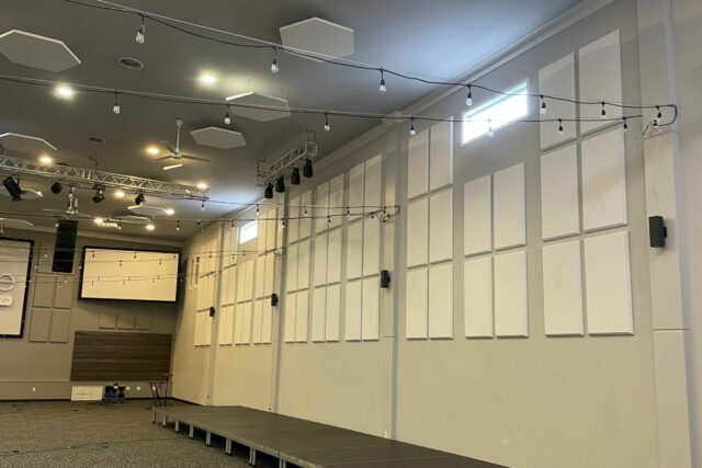 Church wall with white acoustic panels and hexagonal ceiling clouds