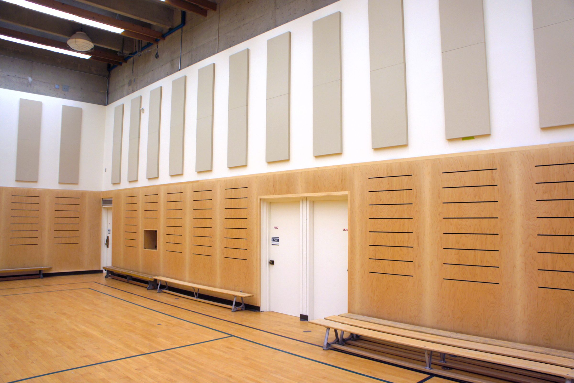 Empty basketball court with grey acoustic column panels on walls