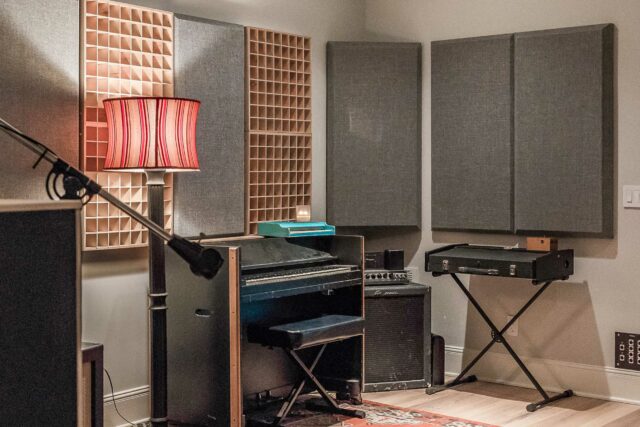 Grey acoustic panels and wooden sound diffusers hanging on acoustic studio walls