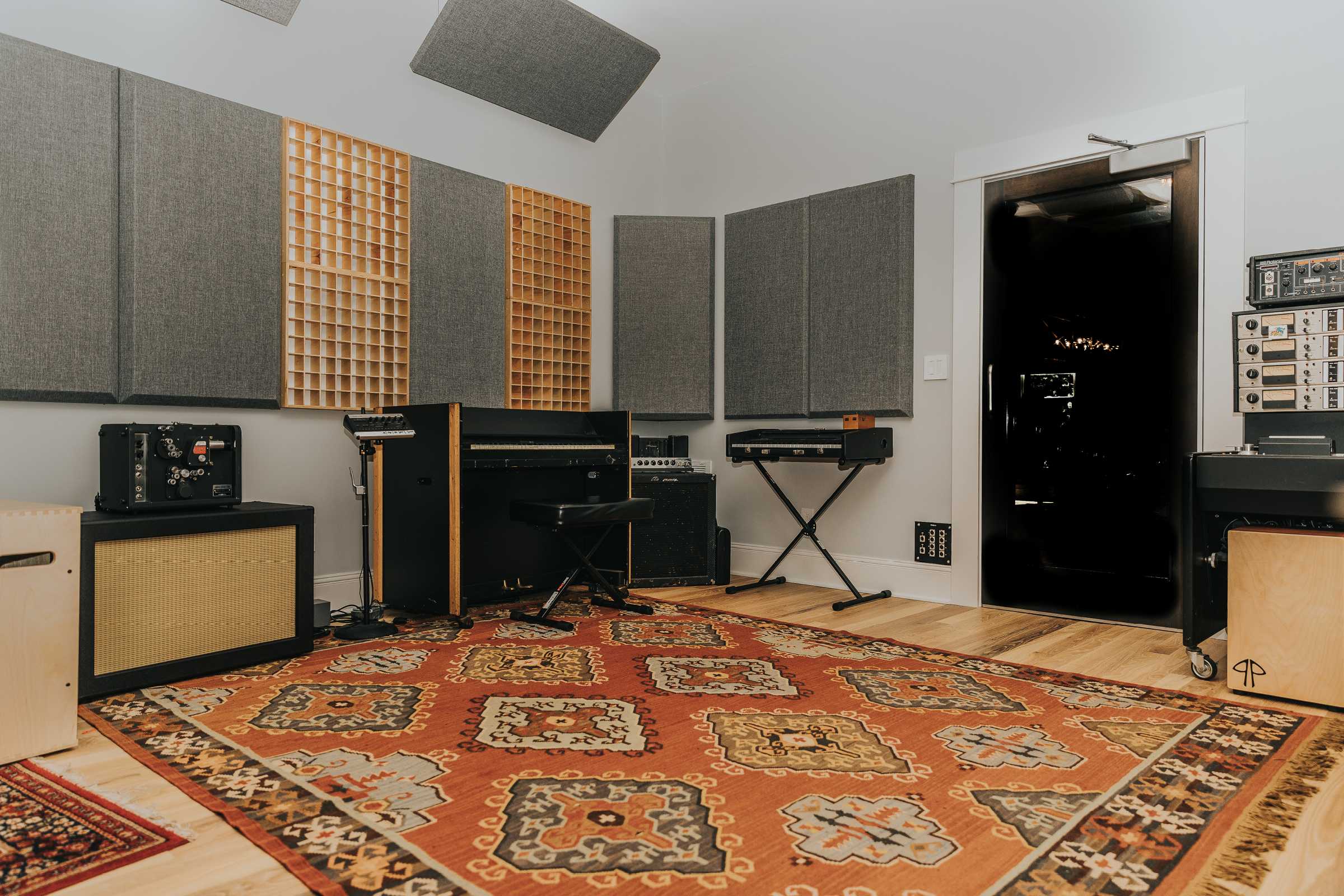 Empty recording studio space with grey acoustic panels and sound diffusers on walls