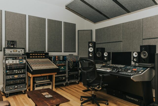 Recording studio mixing room with grey acoustic panels installed on white walls and on ceiling