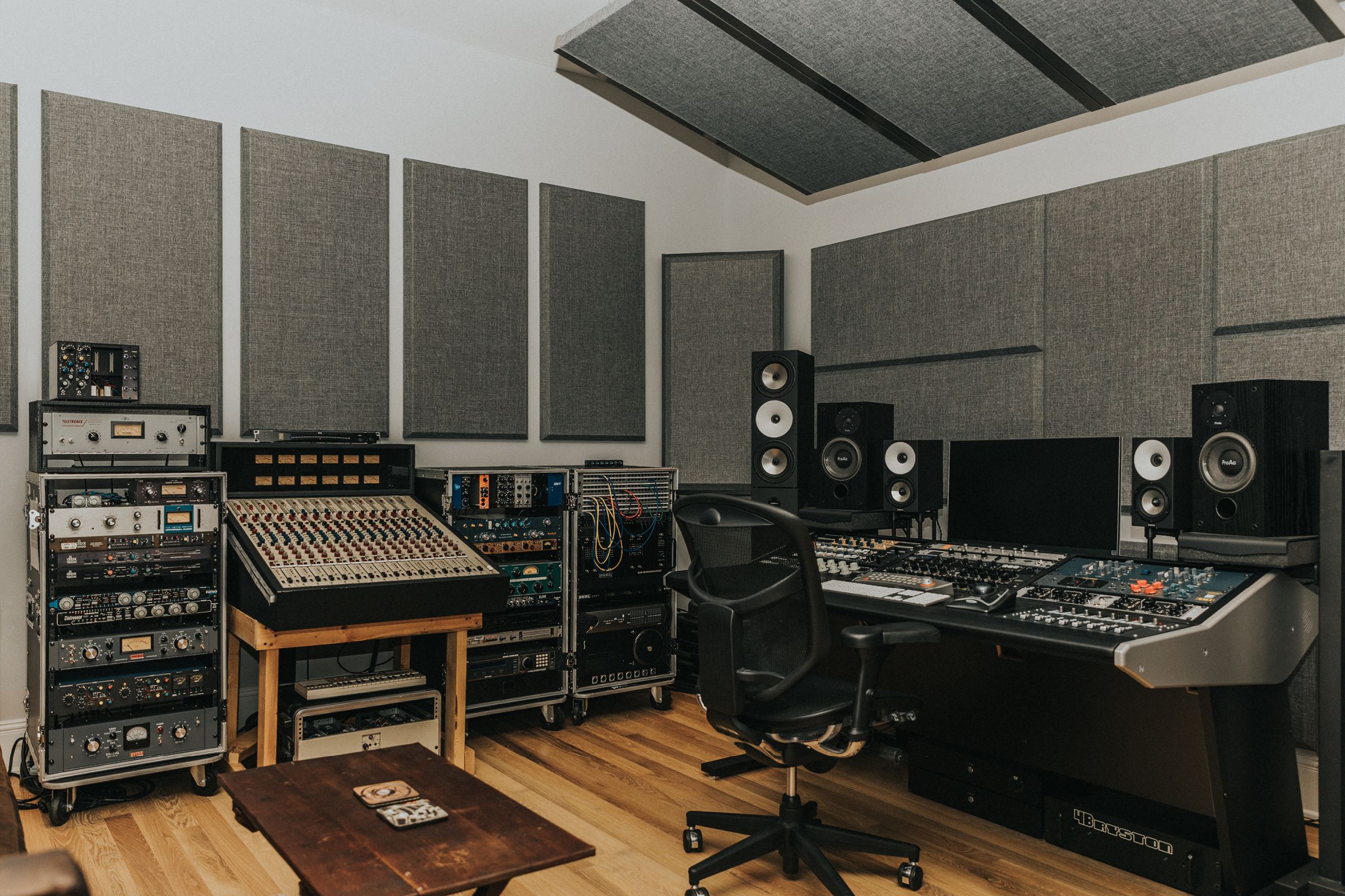 Recording studio mixing room with grey acoustic panels installed on white walls and on ceiling