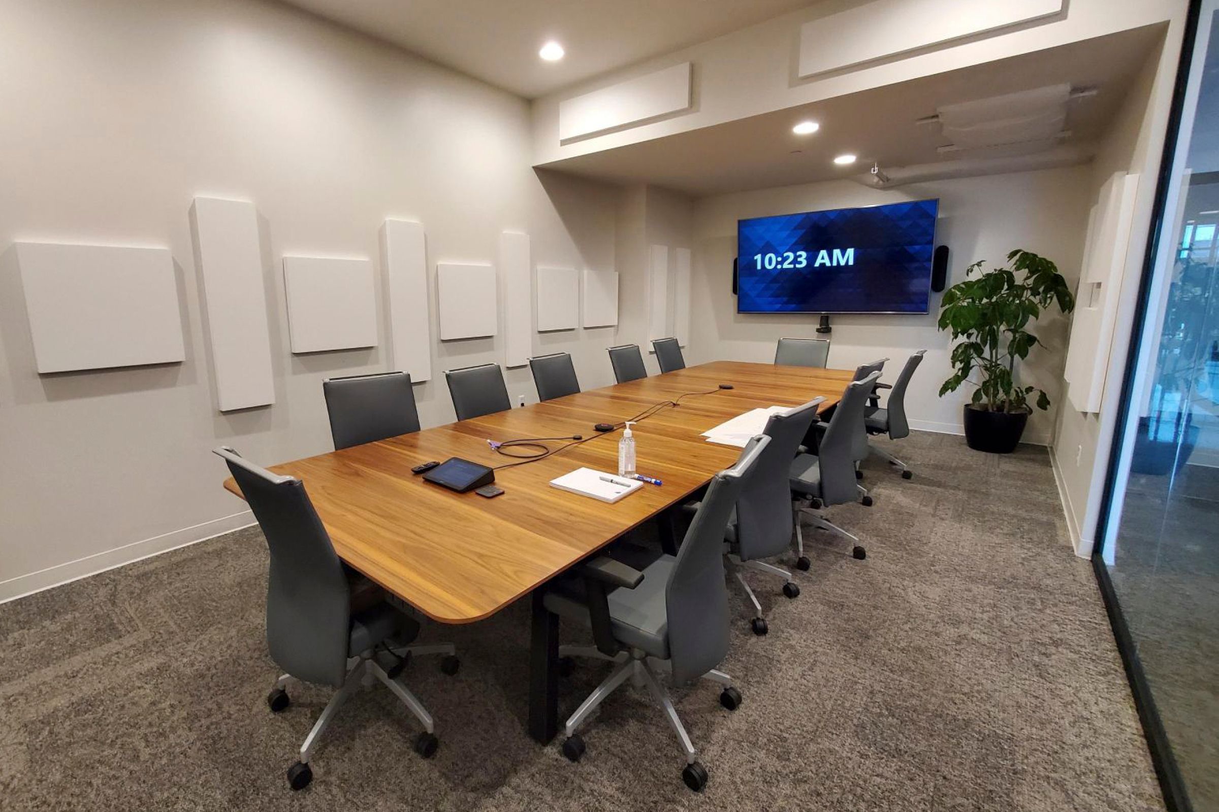 Boardroom with wooden table and white acoustic panels on walls