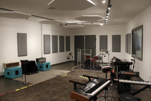 White recording studio room with white hexagonal ceiling acoustic panels and grey wall acoustic panels