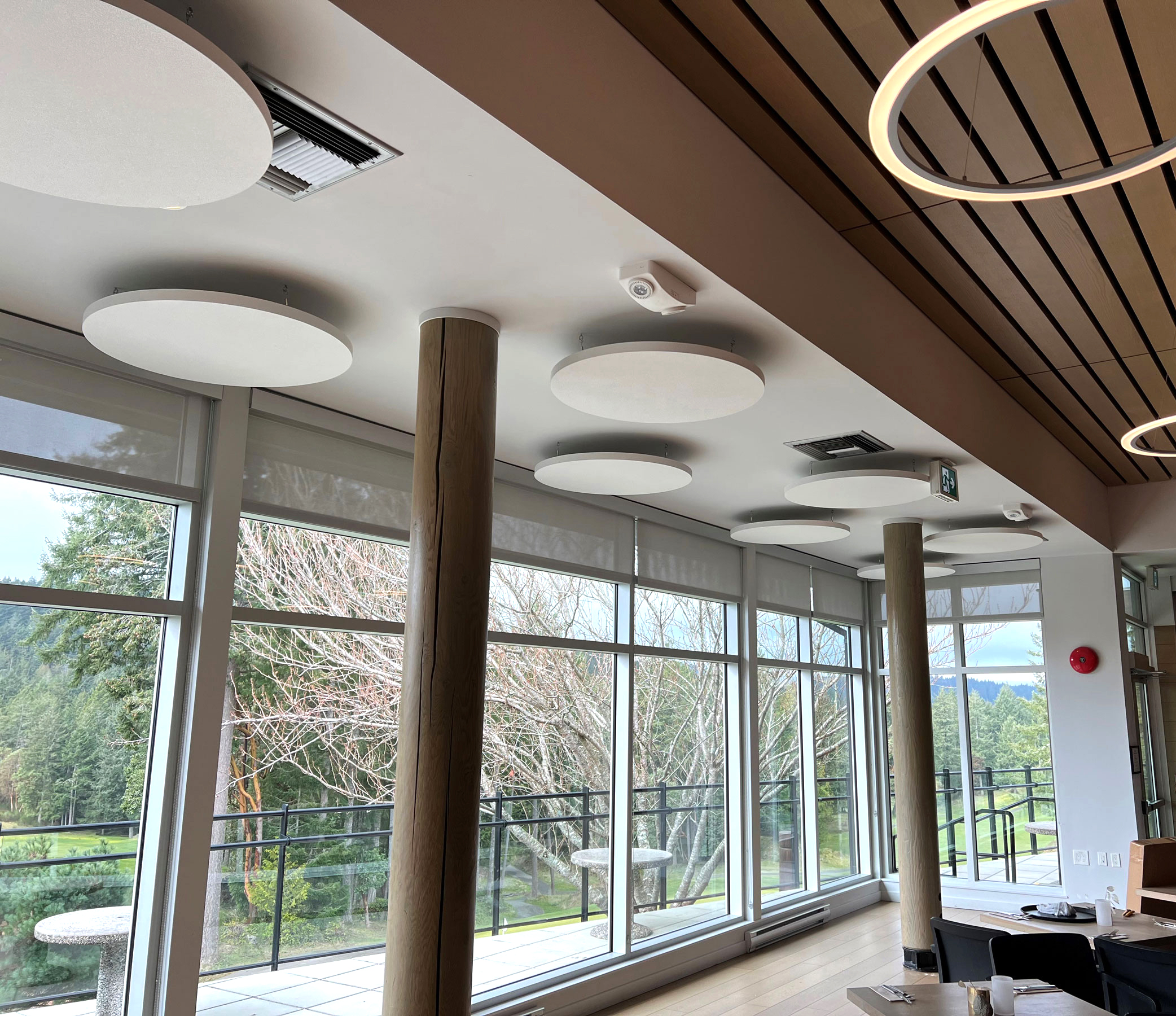 Golf course restaurant with white acoustic clouds on ceiling