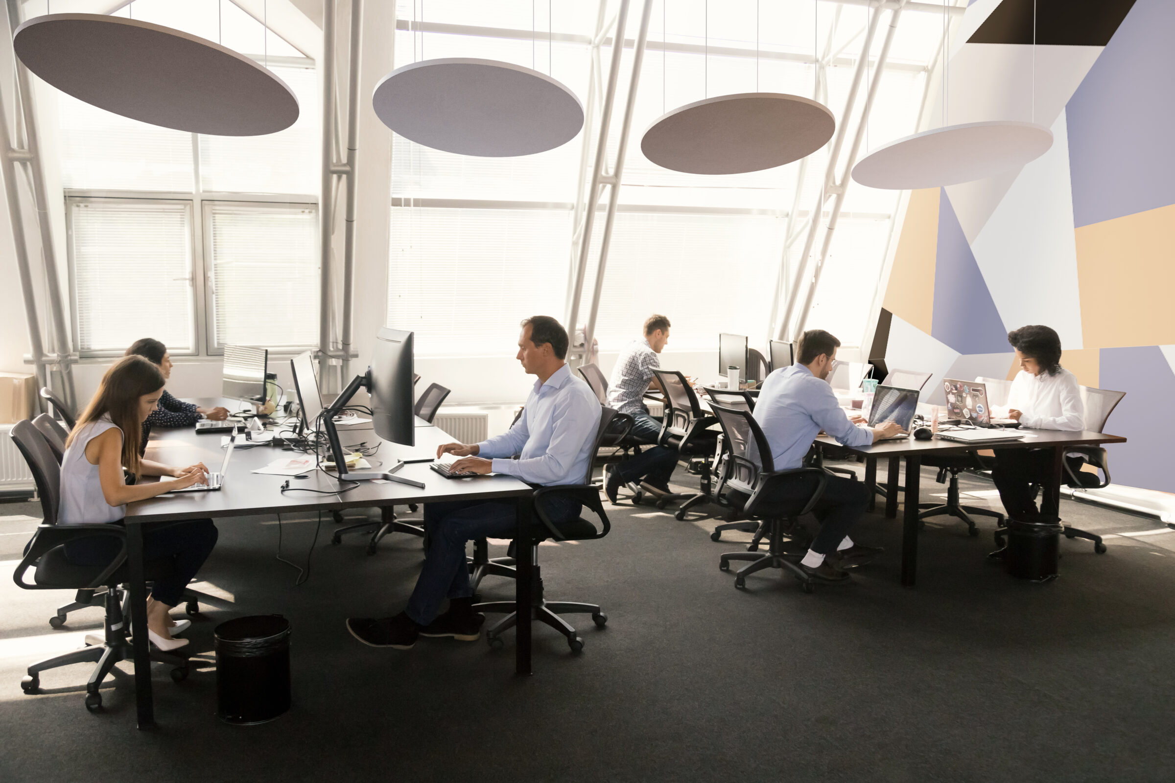 Diverse Workers Sitting At Desk Working In Coworking Space